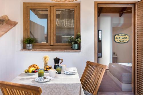 a table with a bowl of fruit on it at Mi Andalusia Hotel Experience in Málaga