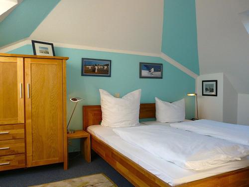 a bedroom with a bed with a blue wall at Schloss Hohenzollern - Fewo mit Meerblick in Ahlbeck