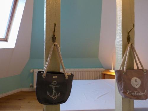 two bags hanging on a pole in a room at Schloss Hohenzollern - Fewo mit Meerblick in Ahlbeck