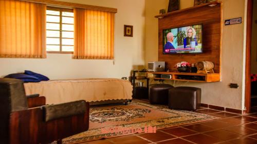 Televisyen dan/atau pusat hiburan di Sitio em Santa Isabel com piscina e natureza