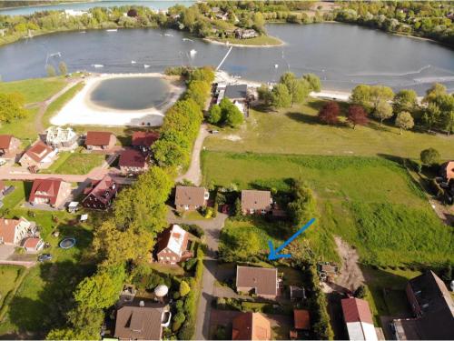 una vista aérea de una casa y un lago en Helena am Badesee, Ferienhaus, en Aurich
