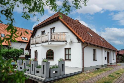 a white house with a balcony on top at Ackerweg, App 02 in Ueckeritz