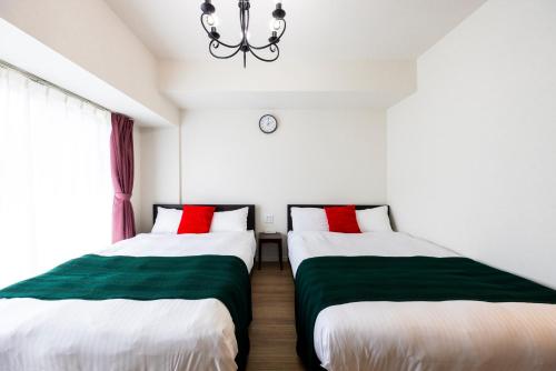 two beds sitting next to each other in a room at Riverside Inn Hakata in Fukuoka