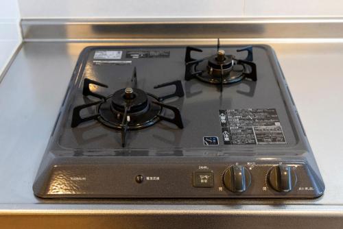 a stove top with two burners on top of it at Riverside Inn Hakata in Fukuoka