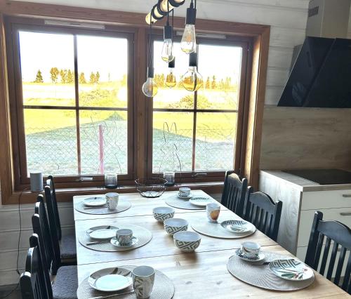 a dining room table with chairs and a large window at Ferienhaus HarzHase in Harzgerode
