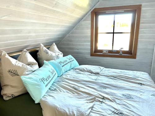 a bedroom with a bed with pillows and a window at Ferienhaus HarzHase in Harzgerode