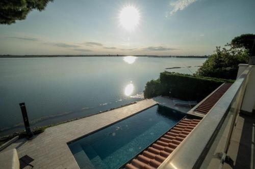a swimming pool in front of a large body of water at Aurelia in Palazzo Vianello