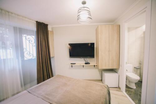 een slaapkamer met een bed en een flatscreen-tv bij Apartment Serpoint in Tbilisi City