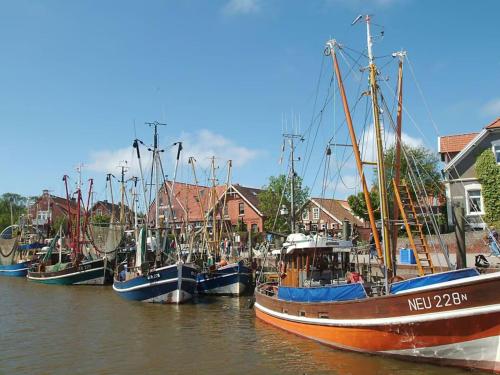 a group of boats docked in the water near houses at Stedesdorf, Ferienwohnung 'Nordsee-Wattwurm' in Stedesdorf