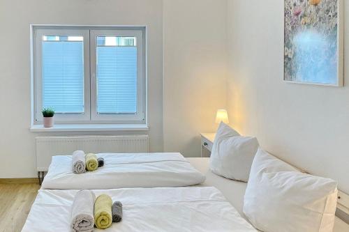 two beds in a white room with a window at Libelle in Lübben