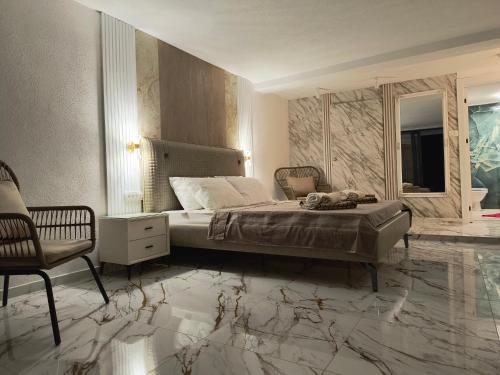 a bedroom with a bed with marble floors and a chair at Villa vista mare in Zagrađe