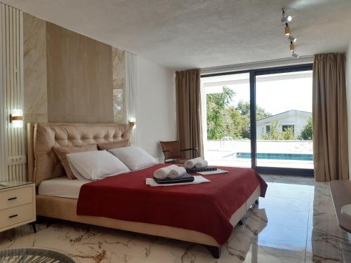 a bedroom with a large bed and a large window at Villa vista mare in Zagrađe
