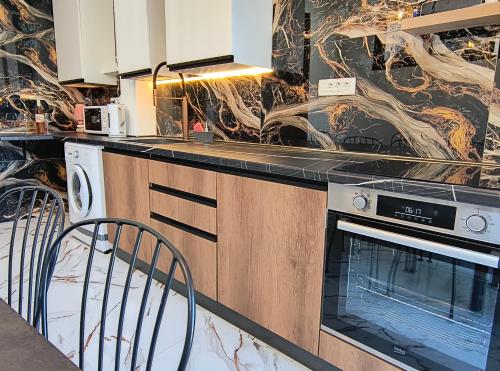 a kitchen with a stove and a counter with chairs at Villa vista mare in Zagrađe