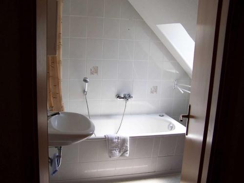 a bathroom with a bath tub and a sink at Ferienwohnungen Seewald in Teterow