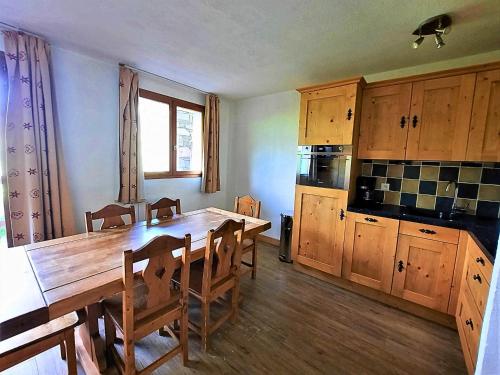 - une cuisine avec une table en bois et des placards en bois dans l'établissement Appartement cosy, 6 pers., pieds des pistes, 2 chambres, balcon sud-ouest, quartier Reberty 1850 - FR-1-452-16, aux Menuires