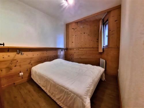 a bedroom with a bed in a wooden room at Appartement cosy, 6 pers., pieds des pistes, 2 chambres, balcon sud-ouest, quartier Reberty 1850 - FR-1-452-16 in Les Menuires