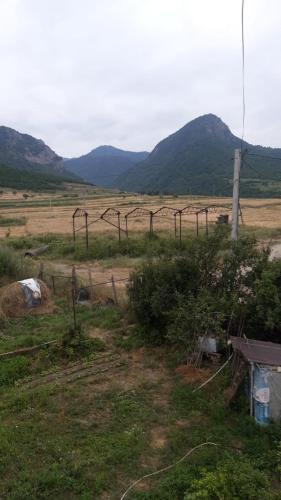 a field with a fence and mountains in the background at Дом на лоне горы с удобствами и красивым видом на горы и сад in Gandzakʼar