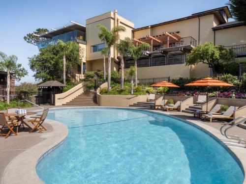 a swimming pool at a hotel with chairs and umbrellas at Hyatt Carmel Highlands in Carmel