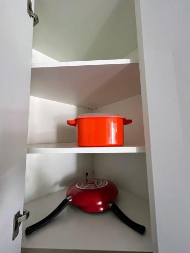 a red pot on a shelf in a kitchen cabinet at Apartamento con Piscina de 2 habitaciones Edificio Brunelo Ciudad de Guatemala, Céntrico in Estación Pamplona
