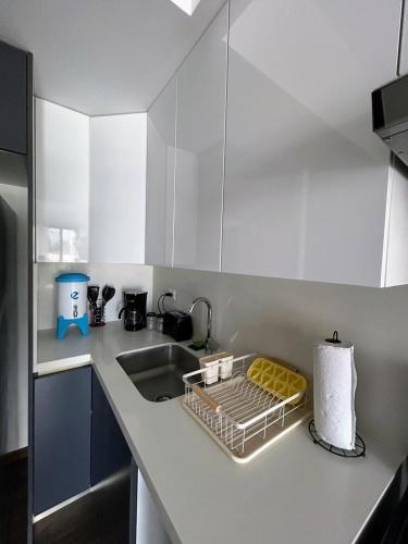 a kitchen with a sink and a dish rack on the counter at Apartamento con Piscina de 2 habitaciones Edificio Brunelo Ciudad de Guatemala, Céntrico in Estación Pamplona