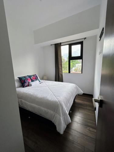 a bedroom with a large bed with a window at Apartamento con Piscina de 2 habitaciones Edificio Brunelo Ciudad de Guatemala, Céntrico in Estación Pamplona