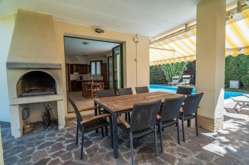 a dining room with a table and chairs and a fireplace at Faggio 14a in Isola Albarella