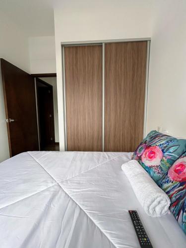 a bedroom with a bed with a remote control on it at Apartamento con Piscina de 2 habitaciones Edificio Brunelo Ciudad de Guatemala, Céntrico in Estación Pamplona