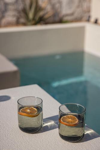 two glasses filled with orange slices on a table at PATHOS Private Villas - Adults Only in Samos