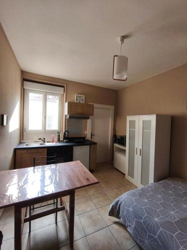 - une cuisine avec un lit et une table dans une chambre dans l'établissement Le Ponsardin, à Reims