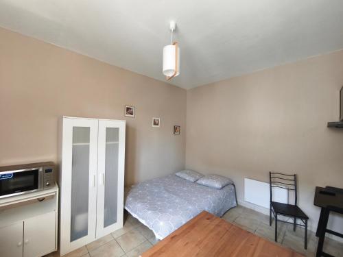 une chambre avec un lit, une table et une chaise dans l'établissement Le Ponsardin, à Reims