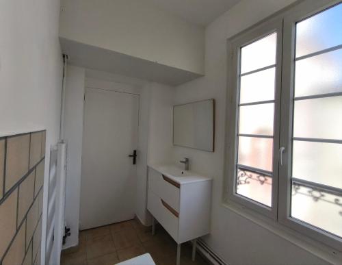 une salle de bain avec un lavabo et une fenêtre dans l'établissement Le Ponsardin, à Reims