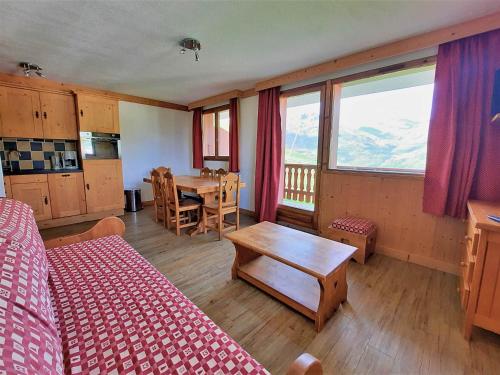 a bedroom with a bed and a table with a view at Appartement 6 personnes aux pieds des pistes, animaux admis - FR-1-452-4 in Les Menuires