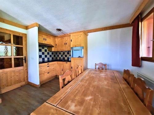 une grande chambre avec une table et une cuisine dans l'établissement Appartement 6 personnes aux pieds des pistes, animaux admis - FR-1-452-4, aux Menuires
