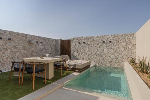 a patio with a table and chairs and a swimming pool at PATHOS Private Villas - Adults Only in Samos