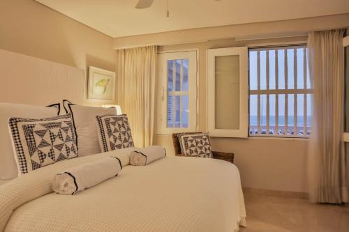 a bedroom with a bed and a large window at Casa La Merced by Mustique in Cartagena de Indias