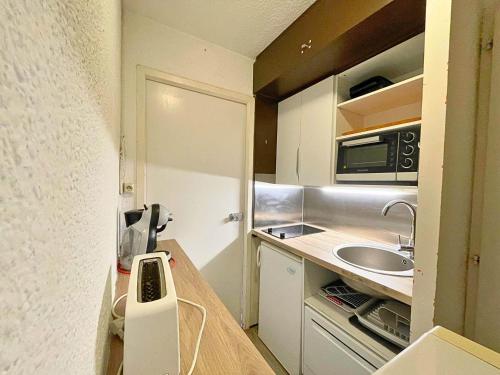 une petite cuisine avec un évier et un comptoir dans l'établissement Studio pour 4 personnes avec balcon Sud, au pied des pistes, centre des Menuires - FR-1-452-99, aux Menuires