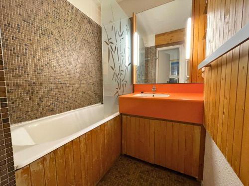 une salle de bain avec une baignoire, un lavabo et un miroir dans l'établissement Studio pour 4 personnes avec balcon Sud, au pied des pistes, centre des Menuires - FR-1-452-99, aux Menuires