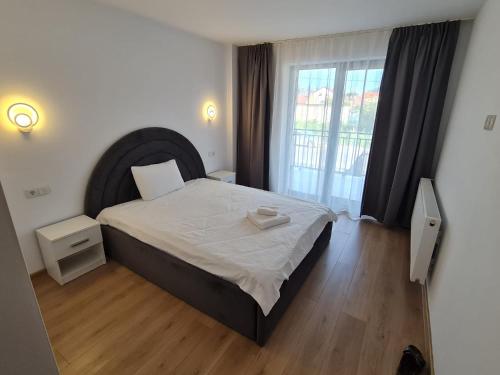 a bedroom with a bed and a large window at Vibe Apartment in Sighetu Marmaţiei