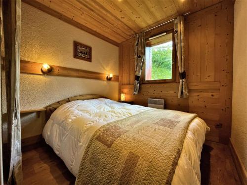- une chambre avec un lit dans une cabine avec une fenêtre dans l'établissement Appartement confort 7 pers, pistes, Sud-Ouest, WIFI, casier à skis, 3 ch, 2 sdb - FR-1-452-384, aux Menuires