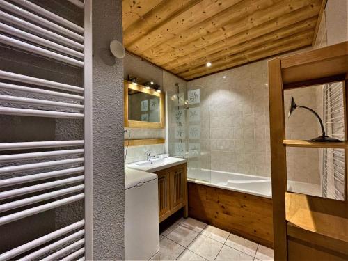 une salle de bain avec un lavabo et une baignoire dans l'établissement Appartement confort 7 pers, pistes, Sud-Ouest, WIFI, casier à skis, 3 ch, 2 sdb - FR-1-452-384, aux Menuires