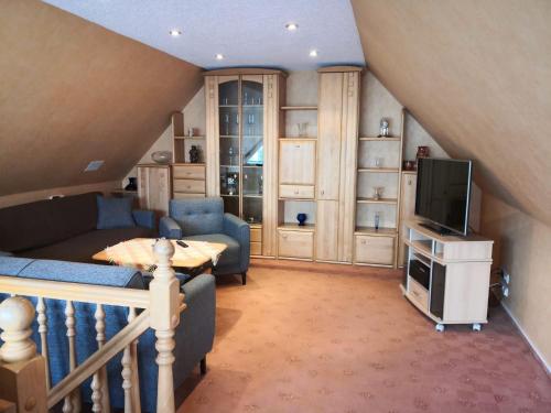 a living room with a couch and a tv at Freude Reetgedecktes Ferienhaus in Ueckeritz