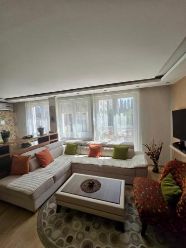 een grote woonkamer met een grote bank en stoelen bij Premium Apartment Vilsonovo in Sarajevo