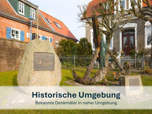 a sign in front of a building with a tree at Stedesdorf, Nordsee Ferienwohnung 'Möwe' in Stedesdorf