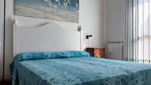 a bedroom with a bed with a blue blanket at Madali in Isola Albarella