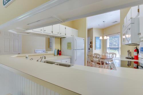 a kitchen with white appliances and a dining room at Walk to Forest Beach Hilton Head Getaway! in Hilton Head Island