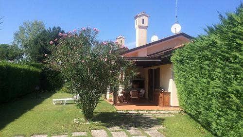 a house with a clock tower in a yard at Madali in Isola Albarella