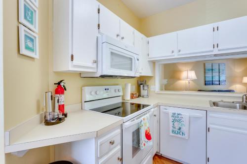 a white kitchen with white cabinets and a sink at Walk to Forest Beach Hilton Head Getaway! in Hilton Head Island