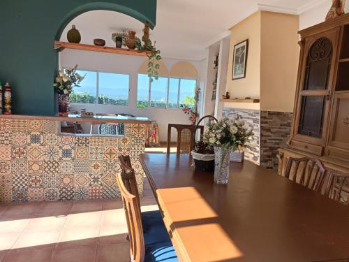 a dining room with a table and a kitchen at Buenas vistas y privacidad, tranquila y fresca villa en el bosque de Valencia con una magnífica piscina de 80m2 in Lliria