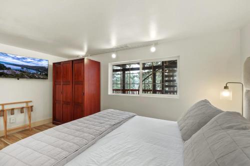 a white bedroom with a bed and a window at Zephyr Cove Zen - Hot Tub & Summer Pool in Zephyr Cove