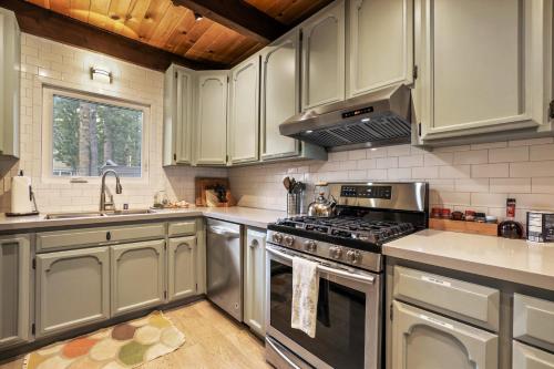 a kitchen with stainless steel appliances and white cabinets at Christmas Valley Chalet - Tahoe Adventure Awaits in South Lake Tahoe